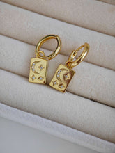 Goldene Ohrringe mit rechteckigen goldenen Platten als Anhänger, auf dem Anhänger sind Mond und Sterne abgebildet, Mond und Sterne haben Zirkonia Steine eingearbeitet